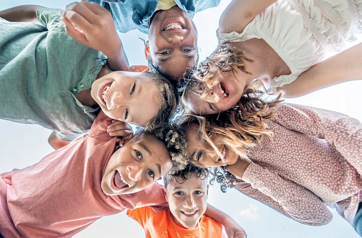 A circle of smiling children looking down at the camera